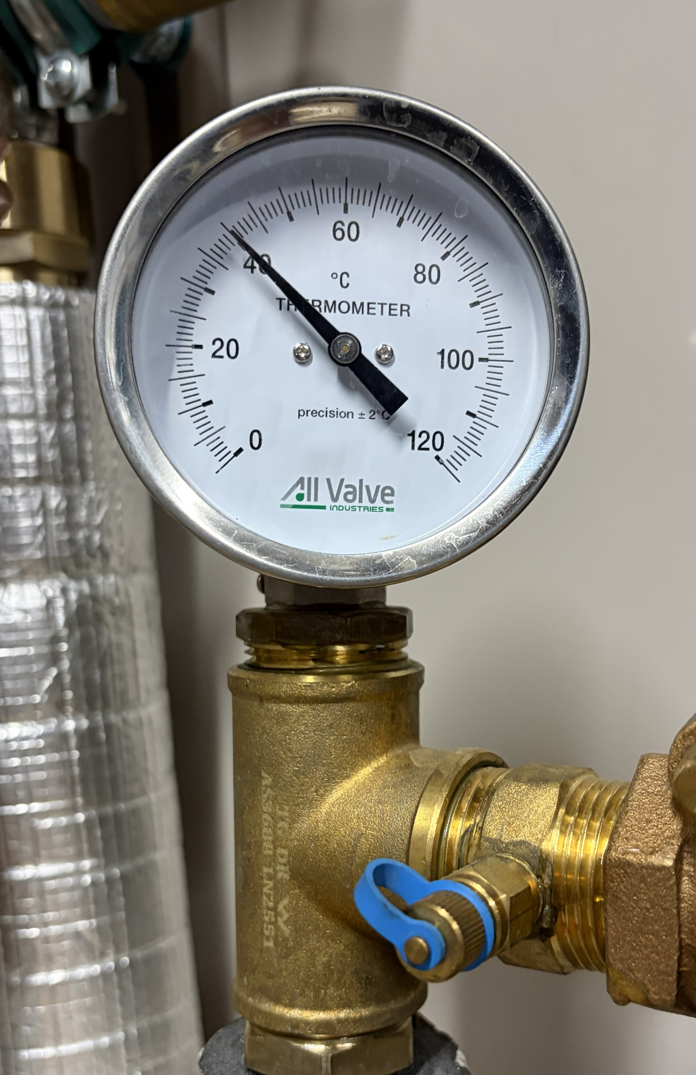 a dail thermoment on a warm water system showing 40 degrees